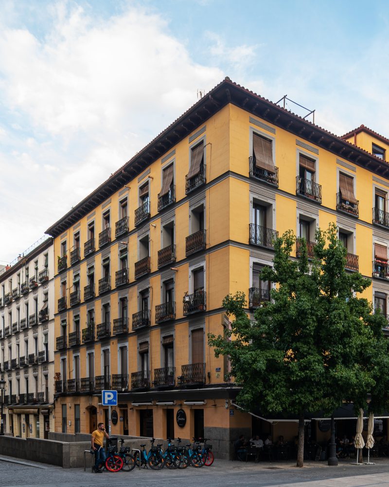 Edificio de fachada amarilla en Doctor Mata 3, en Madrid, con ventanas balconeras de madera